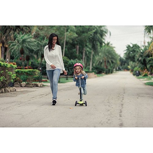 Child riding Oxelo B1 scooter with adult supervision