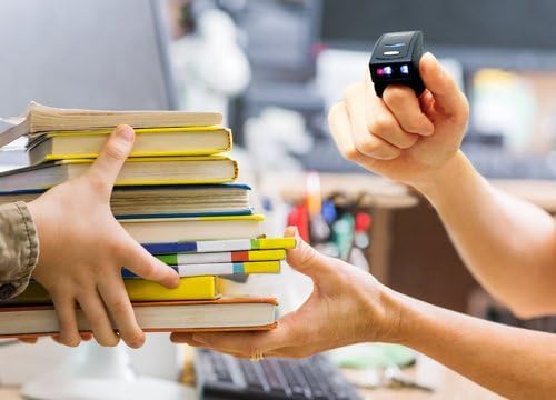 Arkscan AS500 barcode scanner being used to scan barcodes on a stack of books.