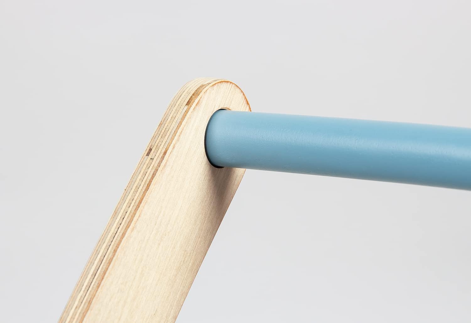 Close-up of the light blue handle bar inserted into a natural wood support, showing the secure connection point of the Pinolino Fiete Learn-Walking Wagon.