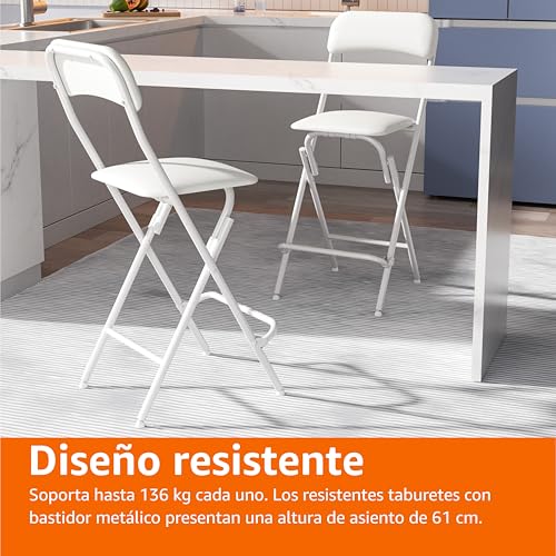 Dos taburetes plegables en color blanco colocados frente a una mesa, destacando su diseño resistente y capacidad de soporte de 136 kg.