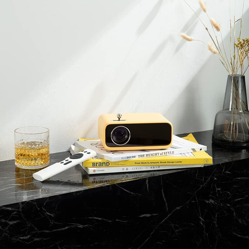 Yellow WANBO MINI XS01 Projector on a table with a remote control, ready for setup.