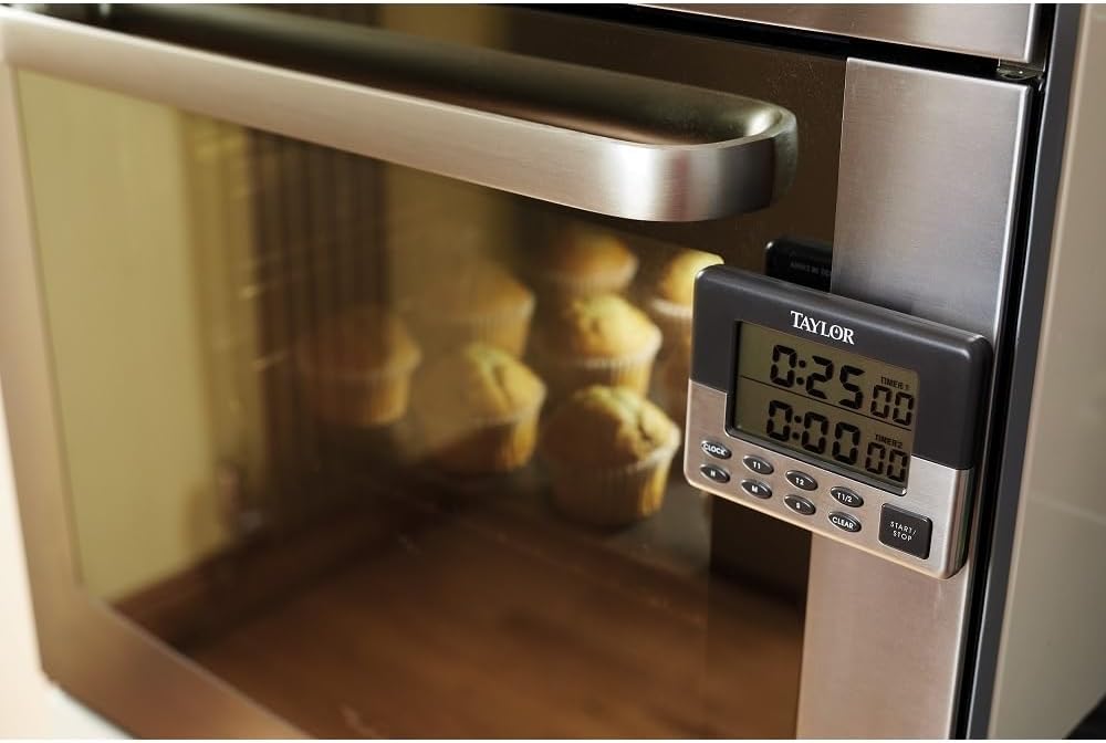 Taylor Pro Dual Digital Kitchen Timer magnetically attached to an oven door, displaying a countdown.