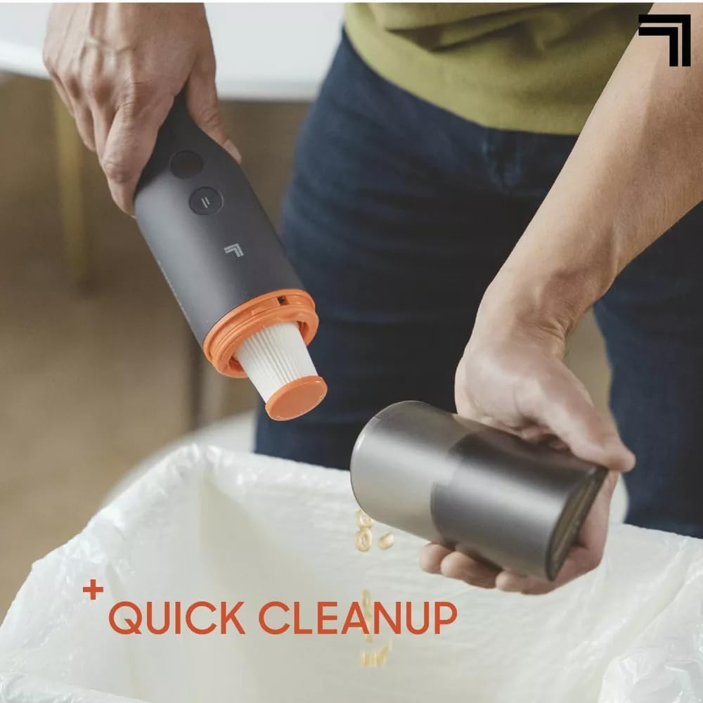 Hands emptying the dust bin of the Sharper-Image Handheld Vacuum