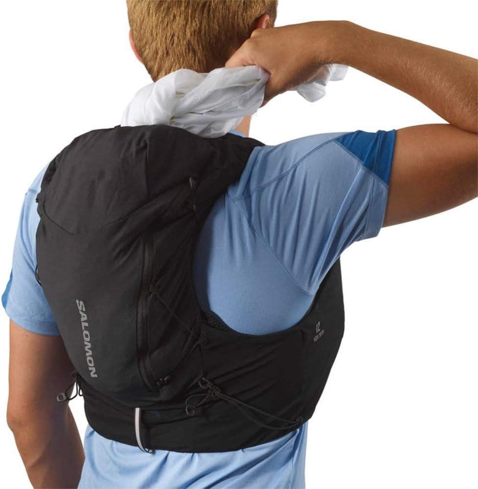 Man wearing Salomon ADV Skin 12 Hydration Pack with poles attached
