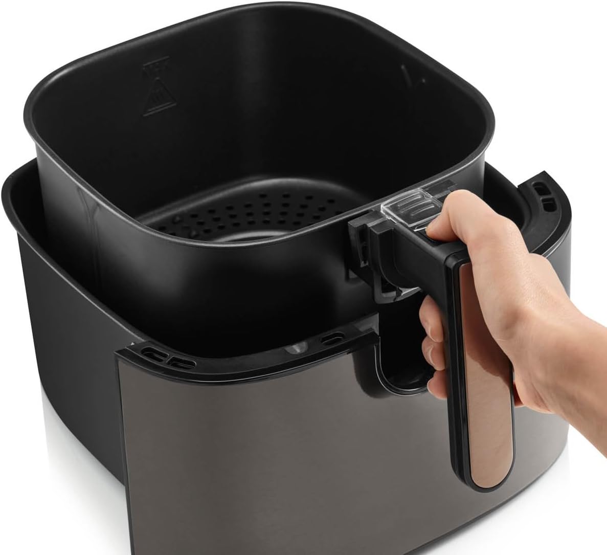 Hand removing the air fryer basket