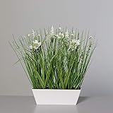 Künstliches Wiesenblumengras in rechteckiger weißer Schale.