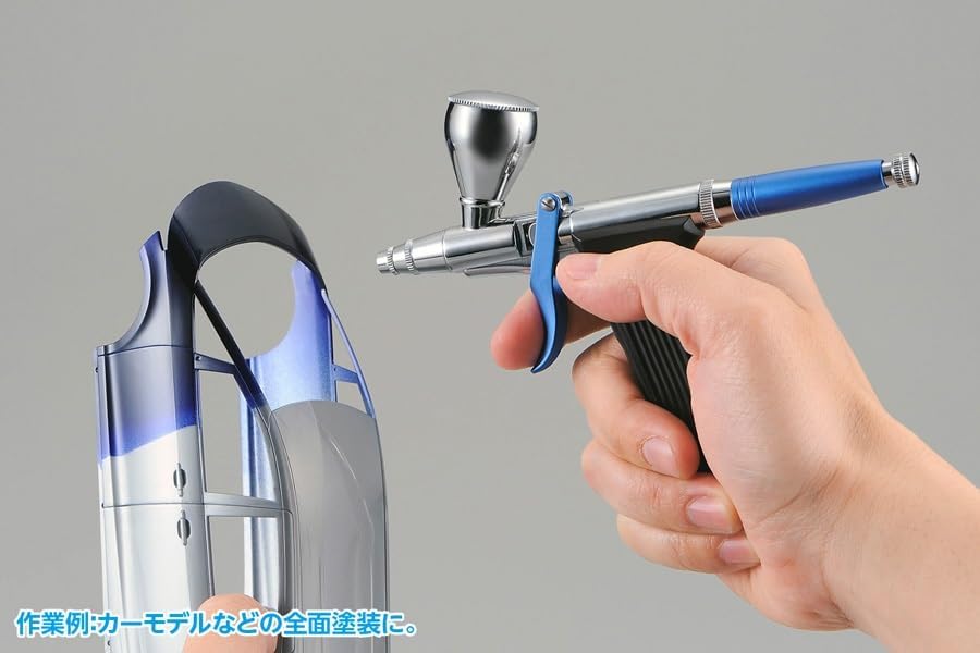 Person airbrushing a model car part