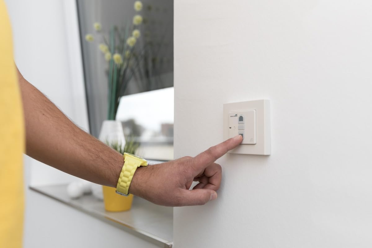 Hand operating a wall switch for roller shutter