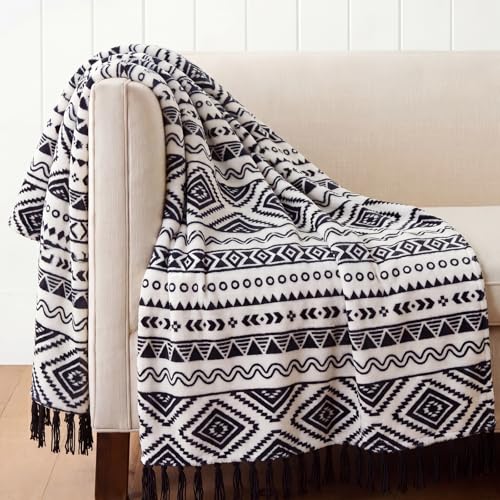 Couverture bohème : sublimez un canapé terne avec ce plaid à pompons