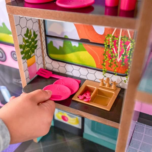 A child's hand arranging accessories in the kitchenette area of the camper
