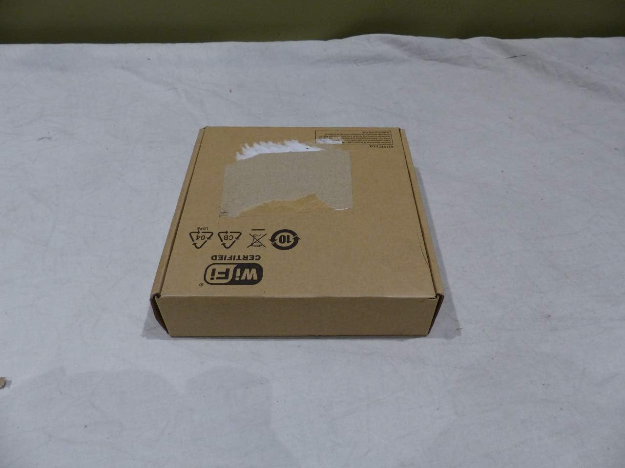 HP Aruba 300 Series Access Point in its brown cardboard box, showing the top of the box with Wi-Fi Certified logo.