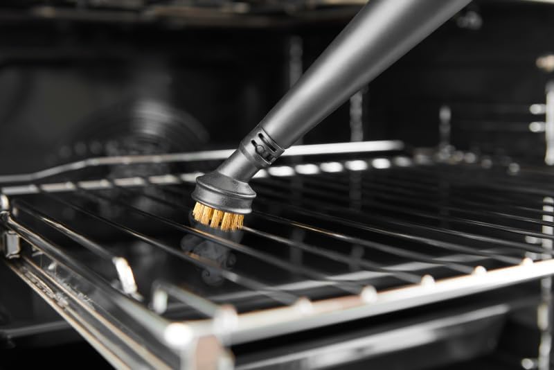Close-up of a brass brush attachment cleaning an oven rack