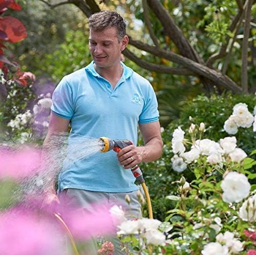 A person using the Hozelock Multi-Jet Spray Gun Pro to water plants in a garden.