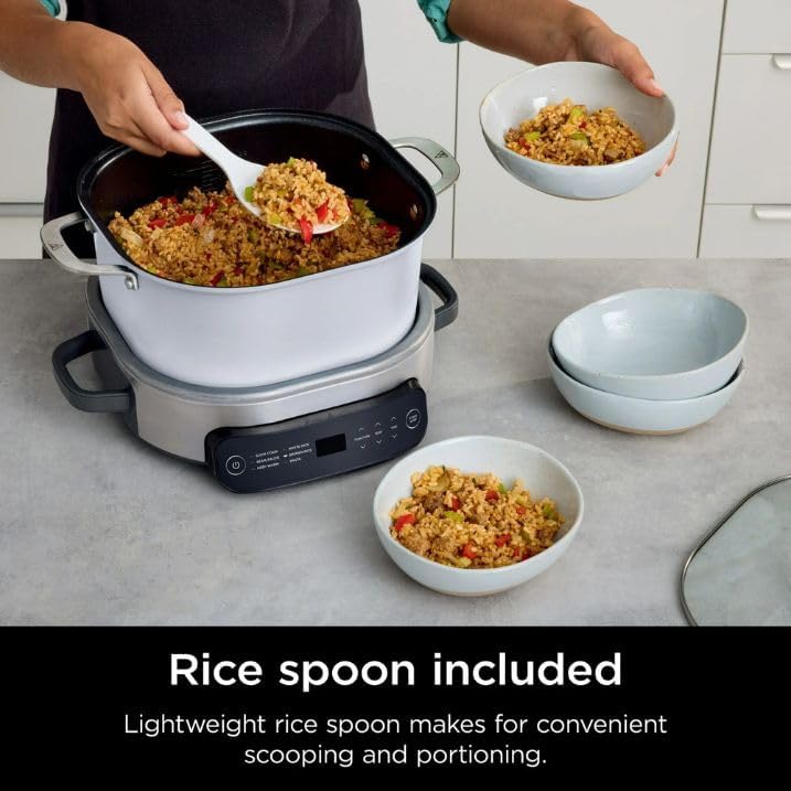 A person serving rice from the PossibleCooker using the included rice spoon.