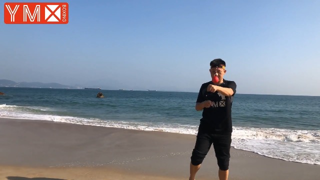 Usuario entrenando en la playa con la pelota de reacción YMX BOXING, mostrando la facilidad de uso y el entrenamiento en exteriores.