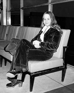 Linda Blair circa 1975 full length pose sits in airport lounge 8x10 inch photo