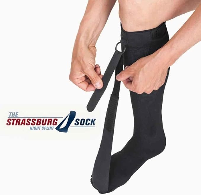 Hands adjusting the Strassburg Sock on a foot, demonstrating how it fits securely to keep the foot in a stretched position for plantar fasciitis relief.