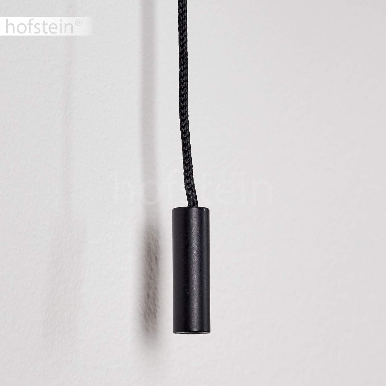 Close-up of the black pull chain switch extending from the base of the white Hofstein Catharine wall sconce.