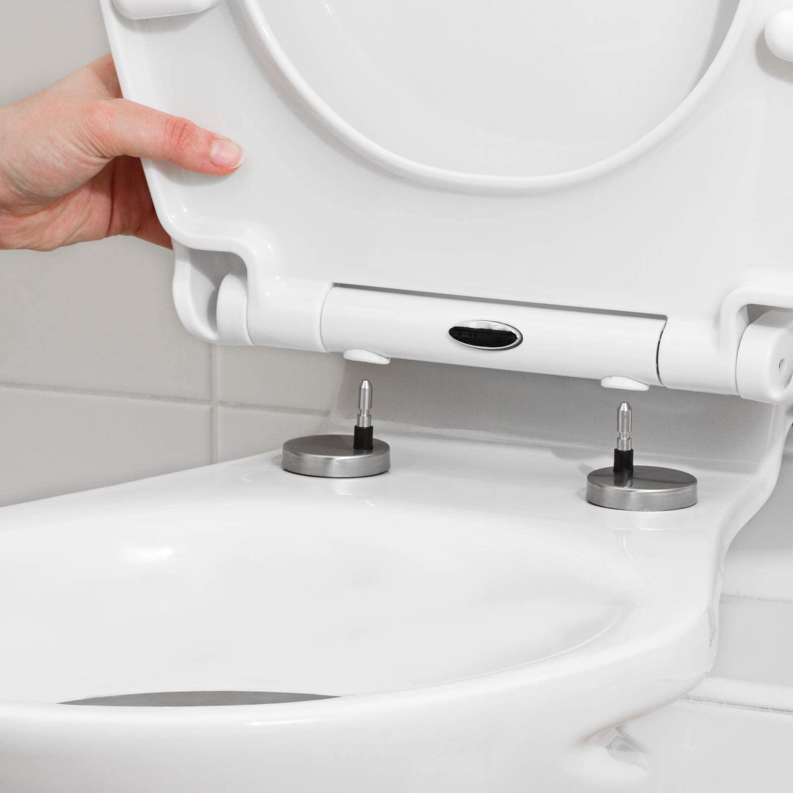 Close-up view of the SA Products Oval Quick Release toilet seat hinge mechanism, highlighting the quick-release button for easy cleaning.