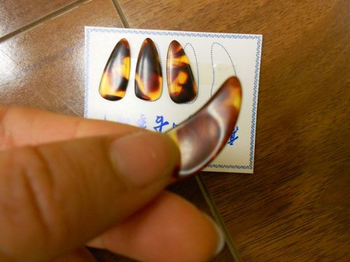 Large side guzheng picks with grooves. Material is celluloid. There are grooves underneath. One set if 8 picks. 4 picks for the right hand and 4 picks for the left hand.