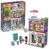 lego friends emma's art cafe Un estudio en la planta superior con un minicaballete, botecitos de pintura y un torno de alfarero giratorio, y una cafetería en la azotea con una mesa y una sombrilla