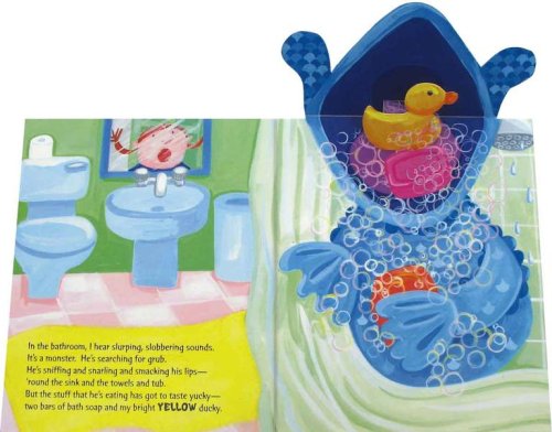 An open page of the Hungry Monsters book showing a blue monster with a pop-up mouth containing a yellow rubber ducky and pink bath soap. Text on the left page describes the monster eating these items.