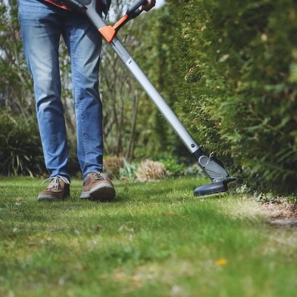 A person using the Yard Force iFlex Urban grass trimmer to trim along a garden path.