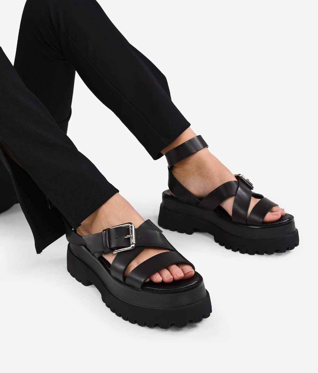 BOSANOVA Sandalias con Total Look Negro compuestas por Tiras Cruzadas al Empeine, Detalle de Hebilla Regulable y Suela Track de 6,5 cm. Cierre con Hebilla. Calzado para Mujer