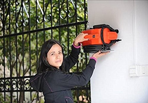 Person demonstrating the wall-mounting capability of the Black & Decker PW1300C Pressure Washer