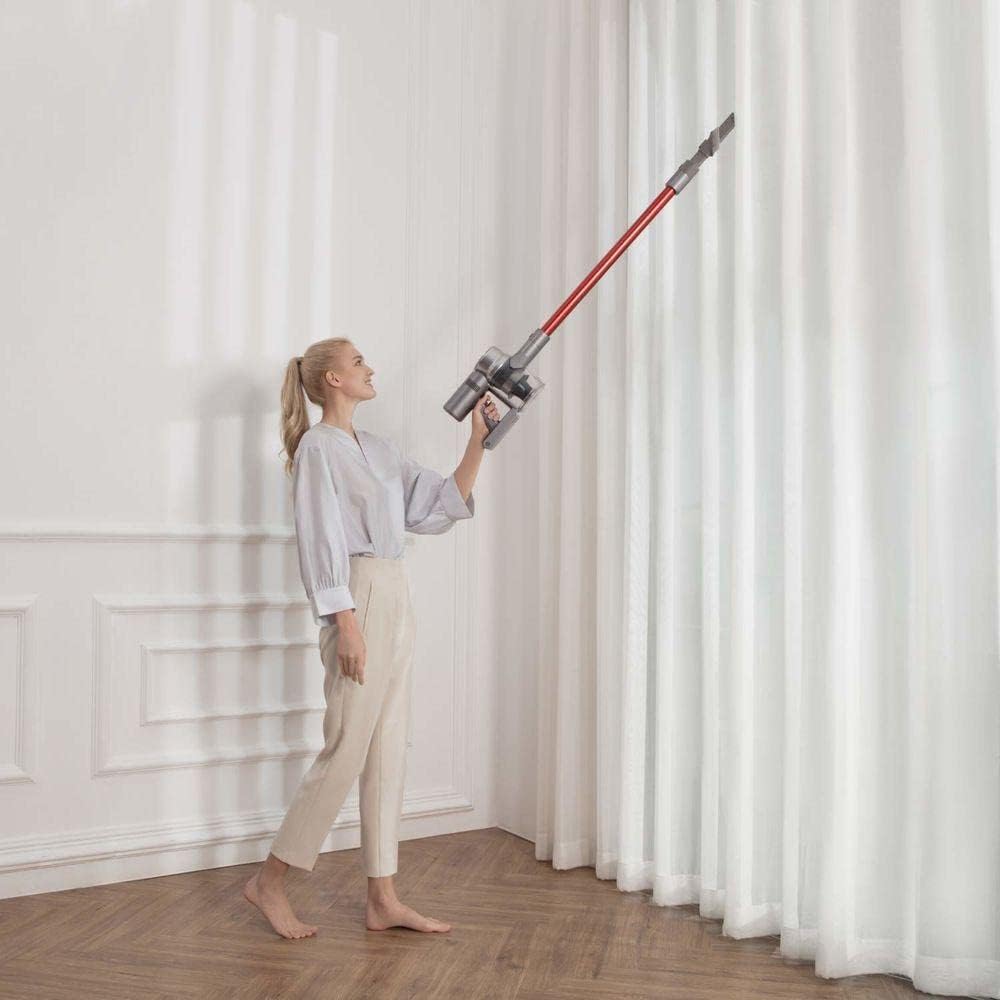 Woman using the Dreame V11 vacuum cleaner to clean high curtains.