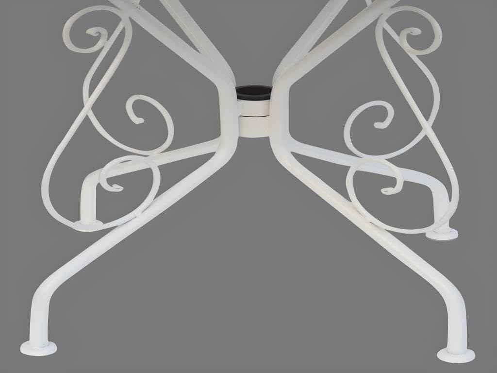 Primer pla view of the underside of the Vente-unique GUERMANTES garden table, showing the central connection point where the leg assembly attaches to the tabletop. The intricate scrollwork of the metal legs is visible.