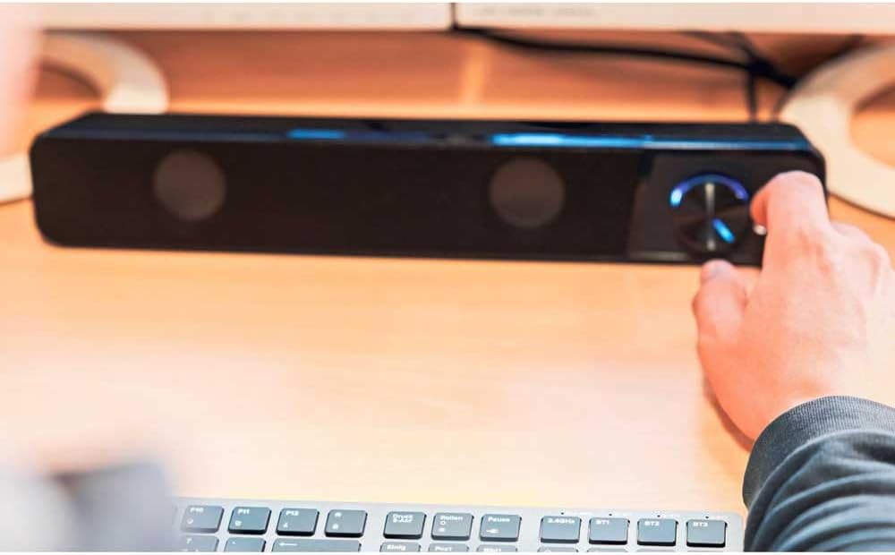 Hand adjusting the illuminated volume knob on the Speedlink BRIO Stereo Soundbar