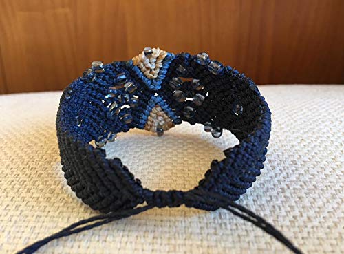 Brazalete macrame hecho a mano con hilo encerado color azul marino y detalles en contraste. Cierre ajustable.