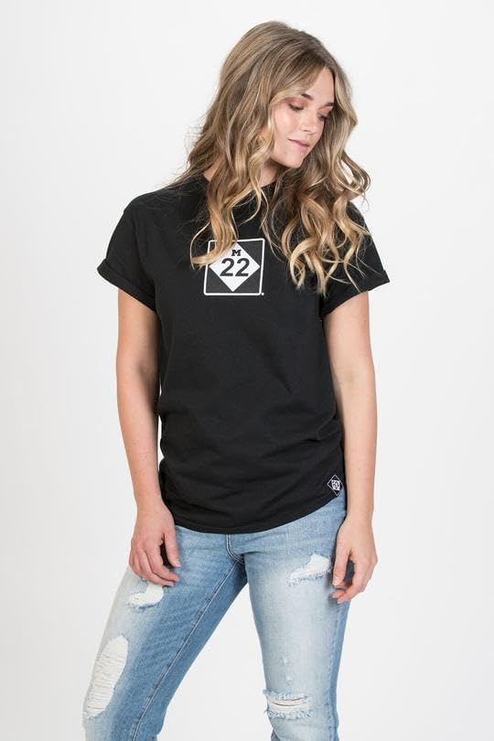 Side view of a woman wearing the black M22 Authentic T-Shirt, paired with jeans.