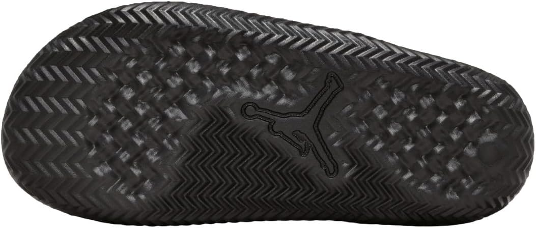 Close-up of the gold Jumpman logo on a black Nike slide