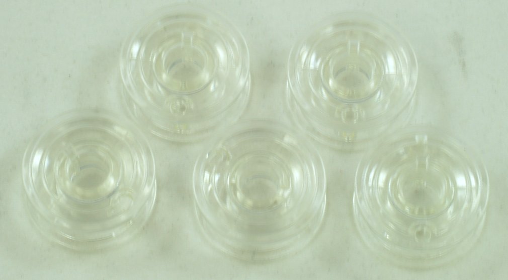 Five clear plastic bobbins stacked together