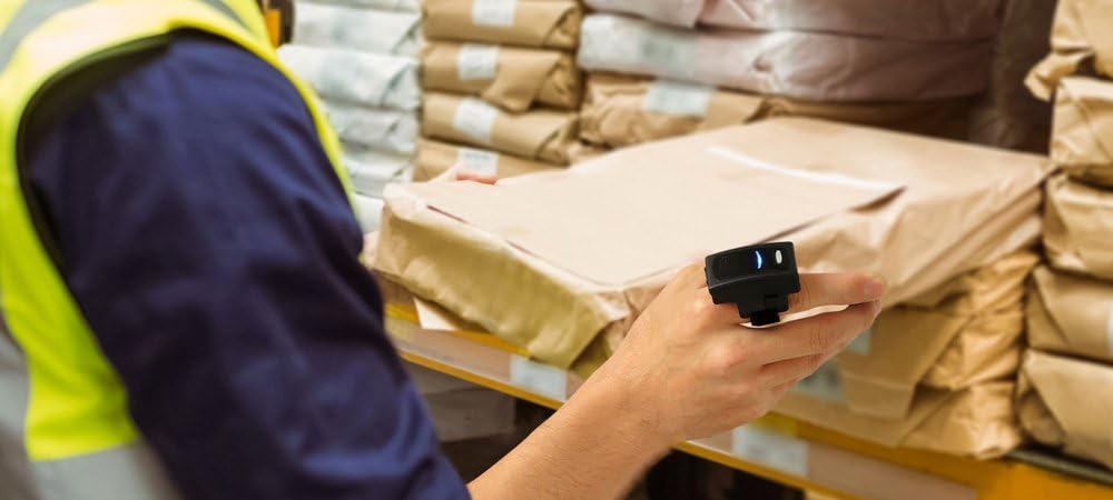 Arkscan AS500 barcode scanner being used by a worker in a warehouse to scan a package.