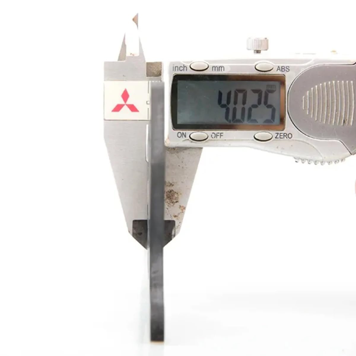 A digital caliper measuring the thickness of a carbon fiber chassis rail, showing a reading of 4.025 mm.