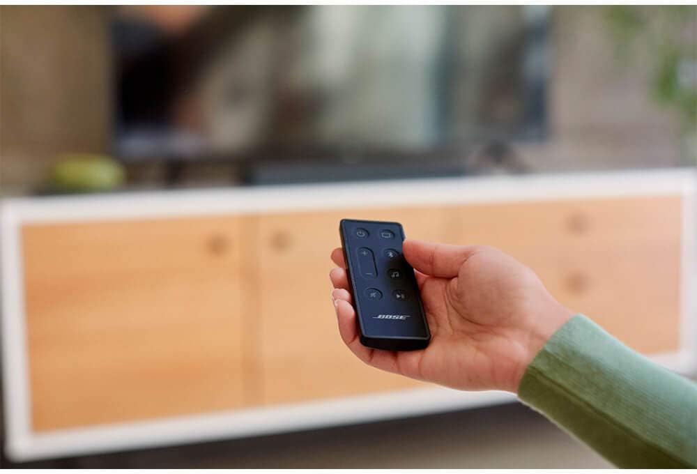 Hand holding Bose Smart Soundbar 300 remote control
