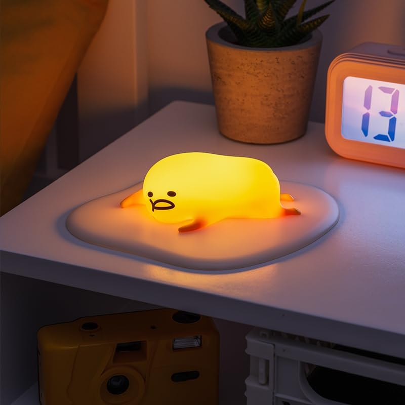 The Paladone Gudetama Icon Light illuminated, casting a soft yellow glow.