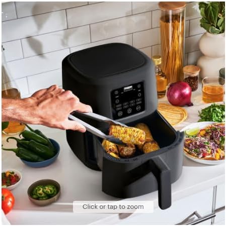User placing food into the air fryer basket with tongs