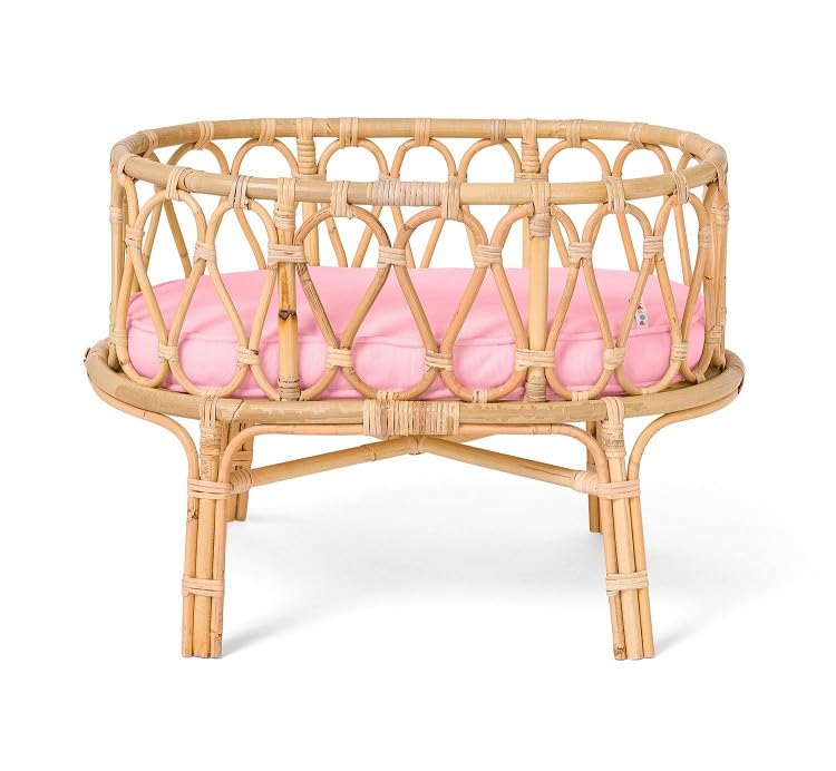 Rattan-Puppenbett mit rosa Matratze.