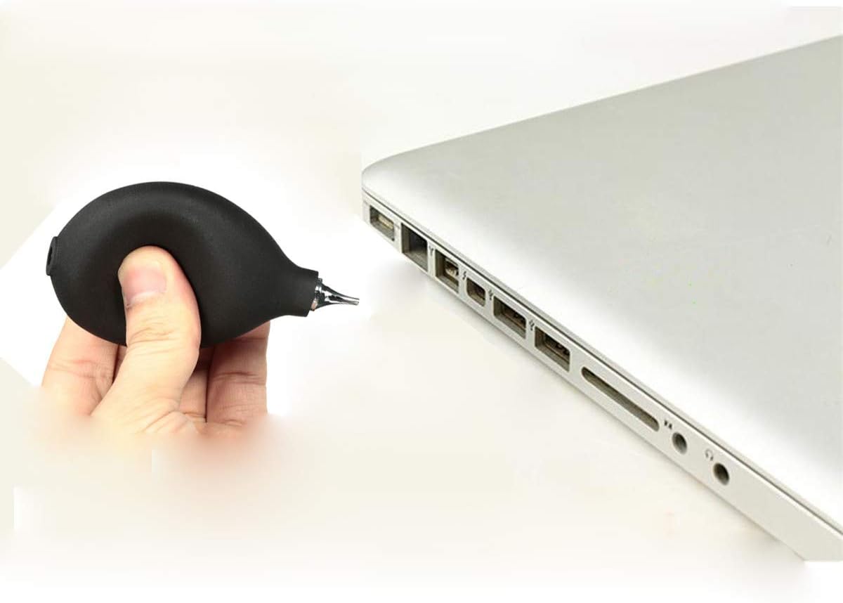 Air blower being used to clean a laptop keyboard