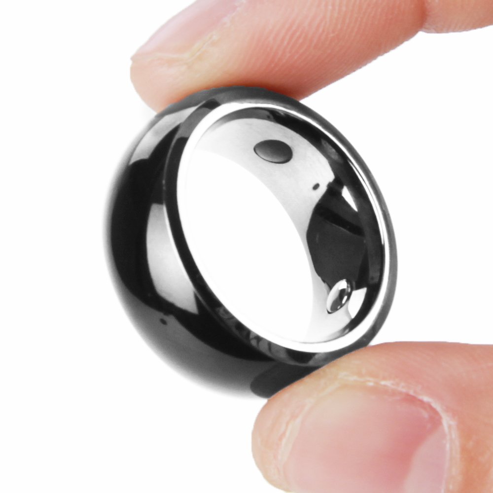 A hand holding the Jakcom R3 NFC Smart Ring between thumb and forefinger