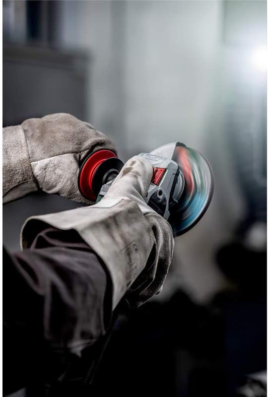 Close-up of a hand pressing the spindle lock button on the Metabo angle grinder