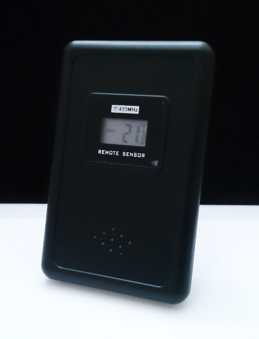 Front view of the black wireless remote sensor for the Sami weather station, showing a small LCD display with '433MHz' and 'REMOTE SENSOR' text, and a temperature reading.