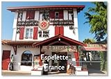 Espelette, Frankreich – Delikatessen- und Souvenirgeschäft befindet sich in traditionellem baskischem rot lackiertem Gebäude, verziert mit hängenden trockenen Espelette-Pfeffern, berühmter