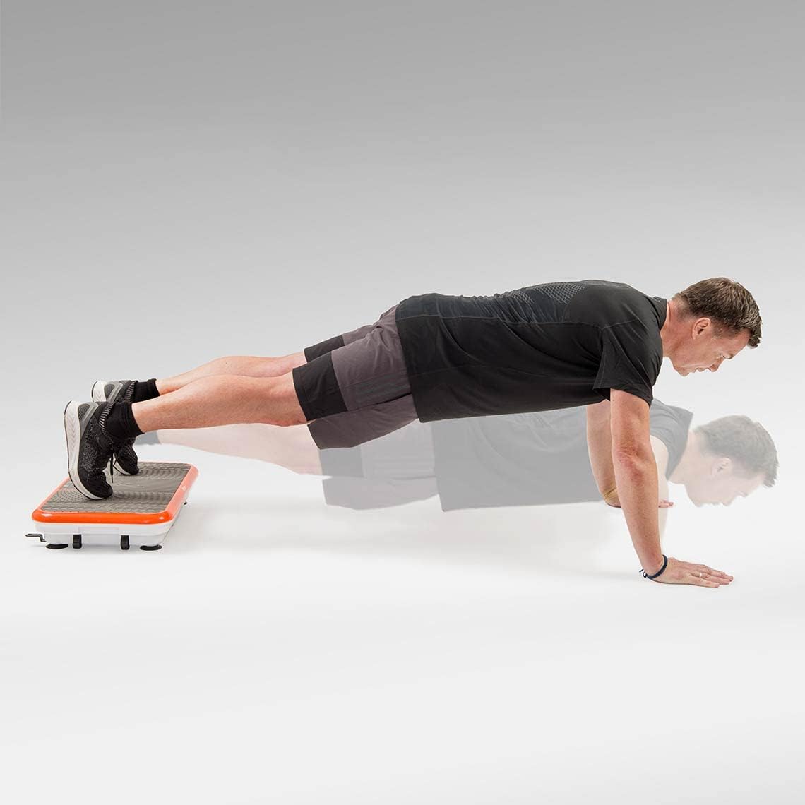 Man performing push-up with hands on Vibro Shaper platform