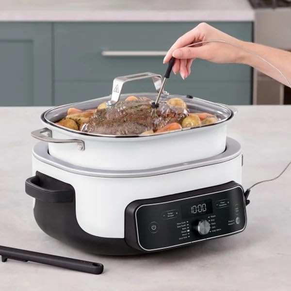 A hand inserting the temperature probe into a roast cooking in the Ninja Foodi PossibleCooker PRO Plus.