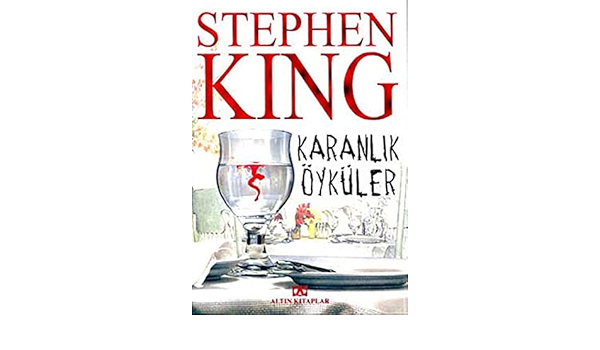 Stephen King'in Karanlık Öyküler romanının kitap kapağı. Kapakta beyaz örtülü bir masanın üstünde içine kan sızmış su bulunan bir kadeh var. Yazarın ismi yazılmak için kırmızı renk ve büyük punto tercih edilmiş.